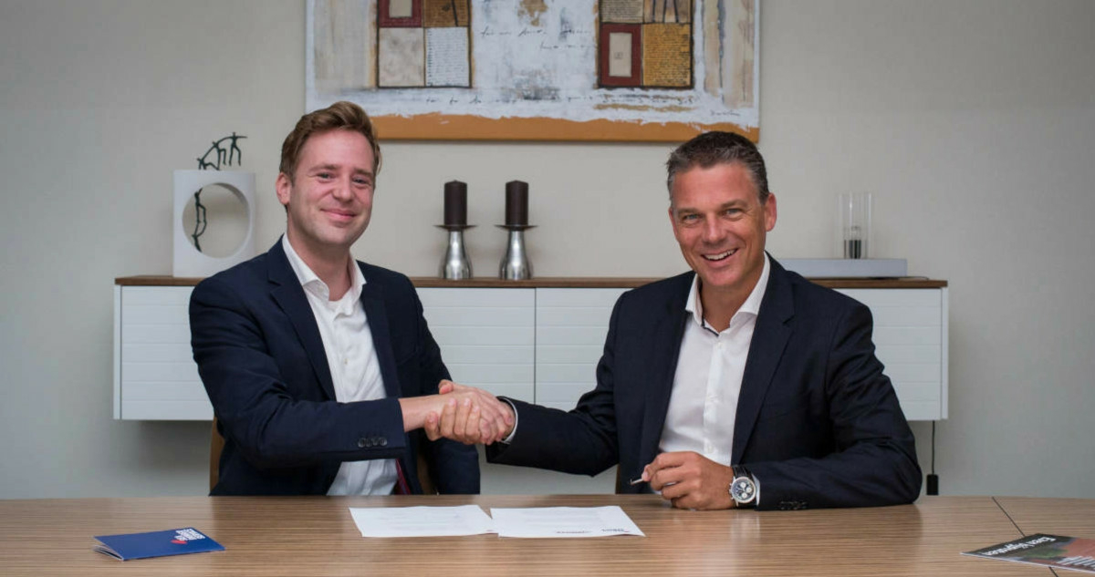 Wietse van der Werf, founder and CEO of Sea Ranger Service shakes hands with Koen van Swam, general manager of the North Sea Farm Foundation, over a signed contract.